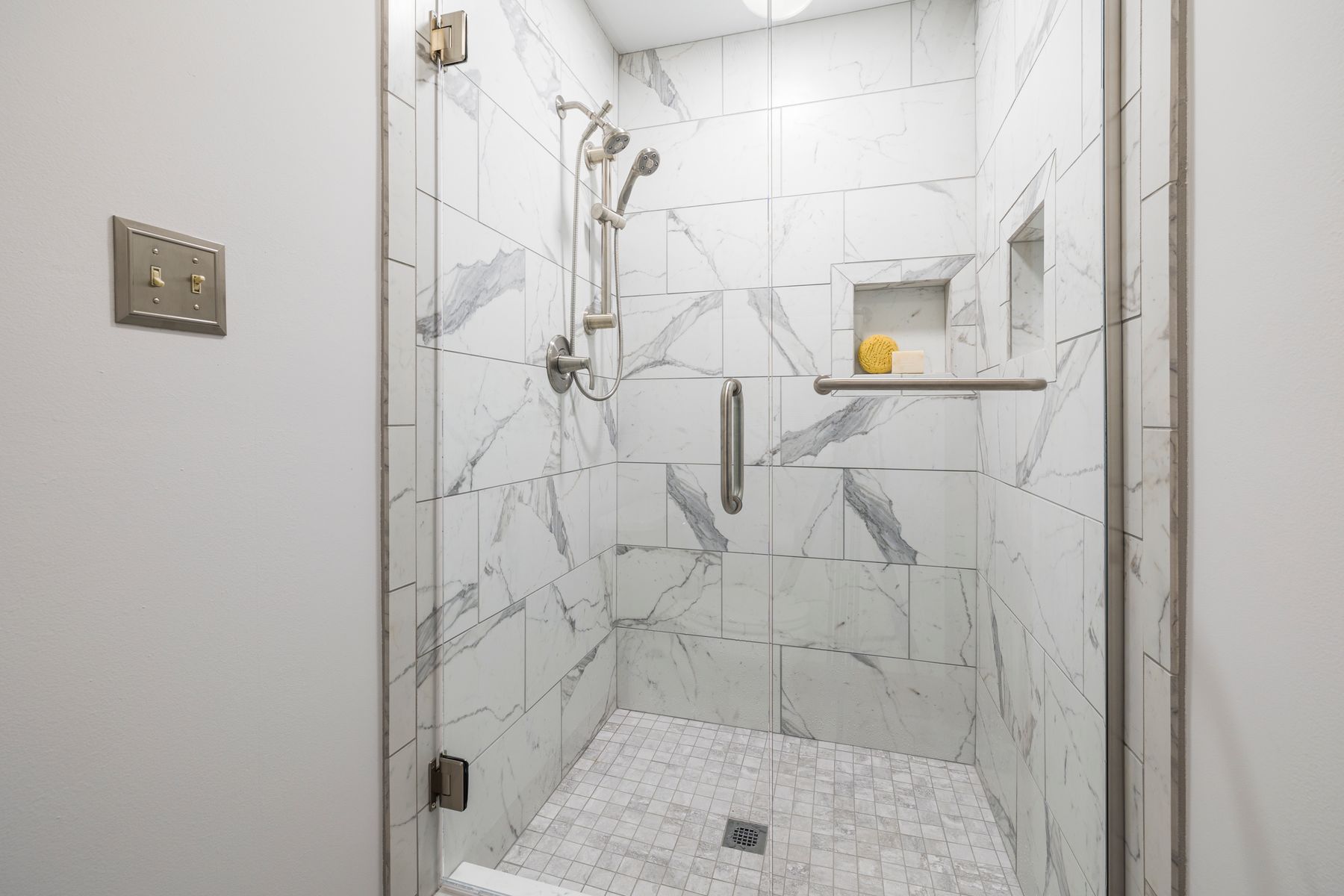 Light marble-look shower walls and bathroom tile