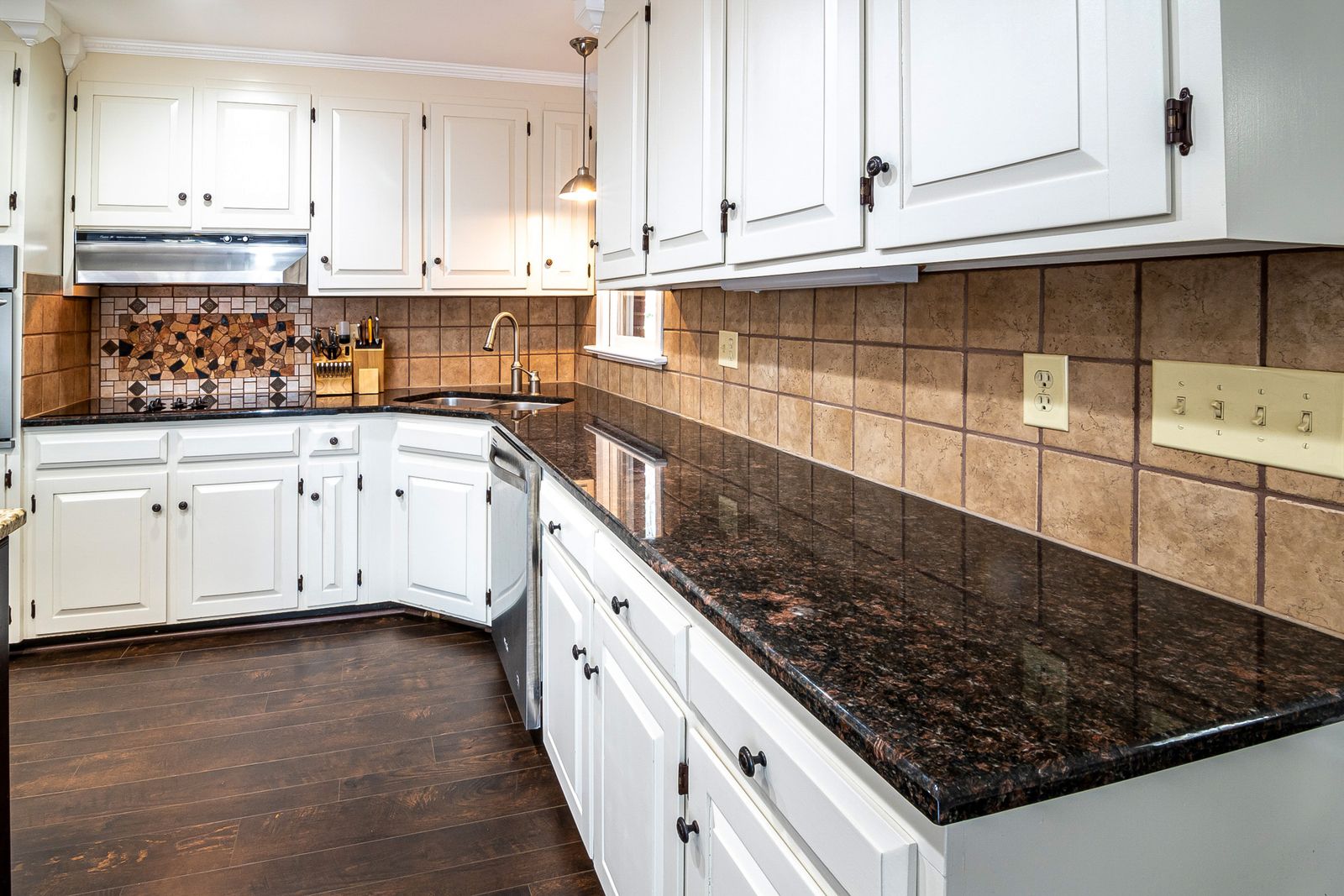 Kitchen with a tiled backsplash and light cabinetry